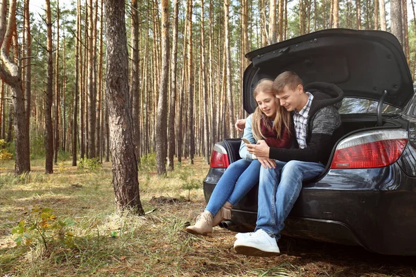 Junges Paar mit Handy in der Nähe von Auto — Stockfoto