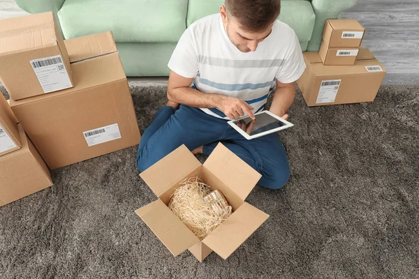 Young man with tablet preparing parcels — Stock Photo, Image