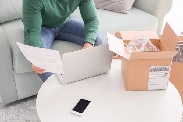 Uomo che utilizza il computer portatile per controllare l'ordine — Foto Stock