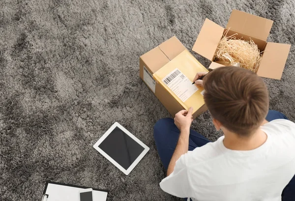 Jovem preparando envelopes de parcelas — Fotografia de Stock