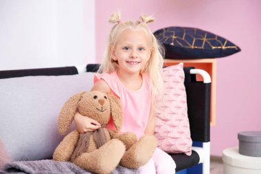 Evdeki kanepede oturan tatlı küçük kız.