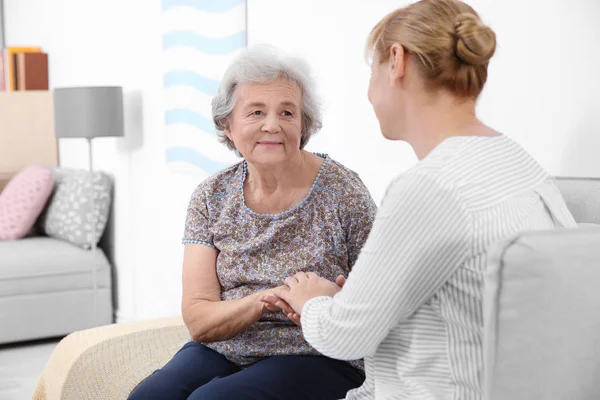 Senior Vrouw Verzorger Zittend Bank Thuis — Stockfoto