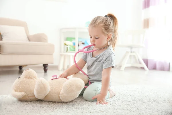 Söt Liten Flicka Med Stetoskop Och Toy Björn Spelar Hemma — Stockfoto