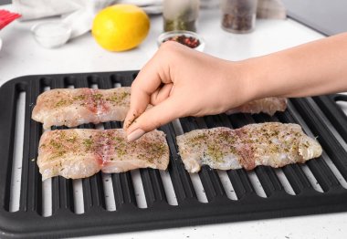 Kadın mutfakta çiğ balık pişirme