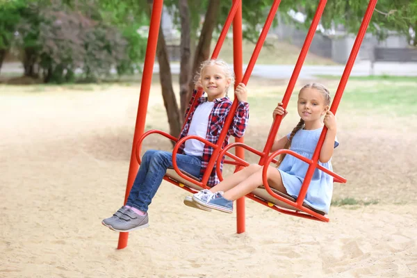 Niedliche Mädchen Auf Schaukeln Auf Dem Spielplatz — Stockfoto