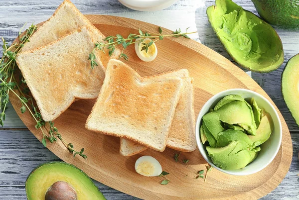 Placa de madeira com saborosas torradas de café da manhã — Fotografia de Stock
