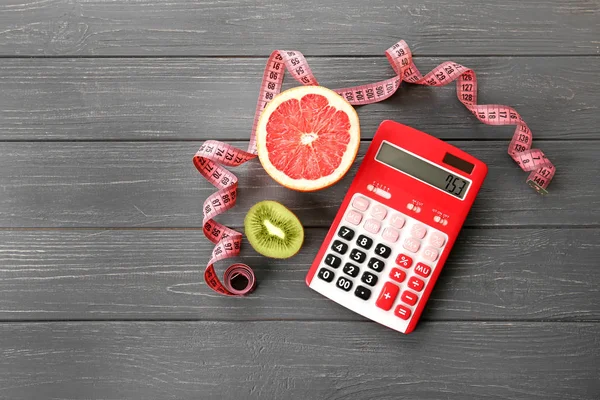 Калькулятор, измерительная лента и грейпфрут — стоковое фото