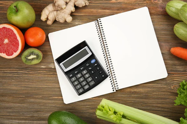 Calculadora, notebook e diferentes mantimentos — Fotografia de Stock