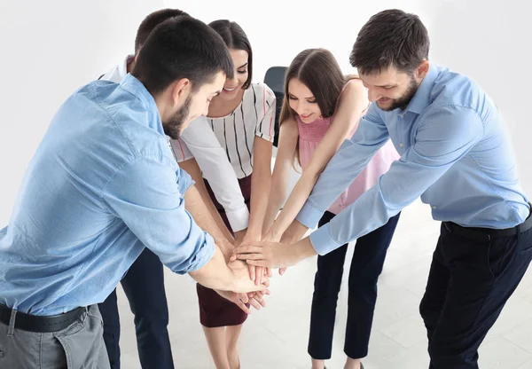 Jóvenes poniendo las manos juntas, adentro. Concepto de unidad — Foto de Stock