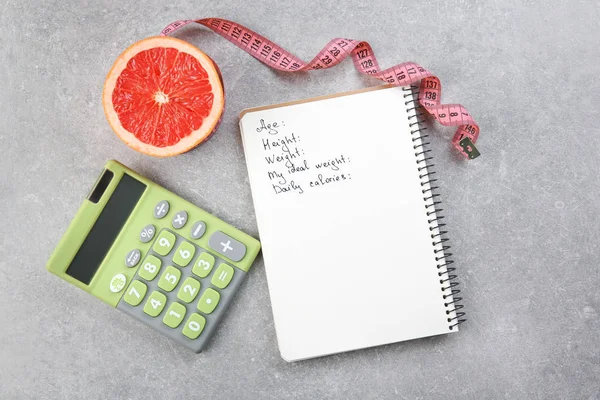 Measuring tape, grapefruit, calculator and notebook — Stock Photo, Image