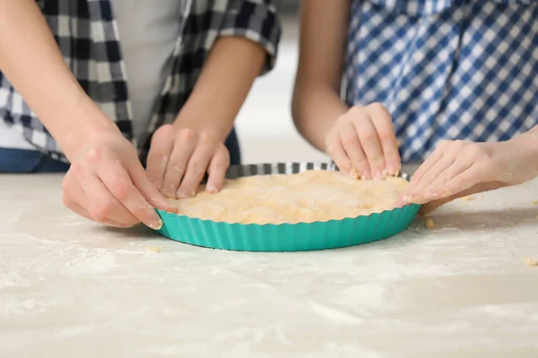 Mother and daughter cooking pie