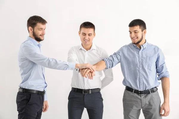 Young men putting hands together against white background. Unity concept — Stock Photo, Image