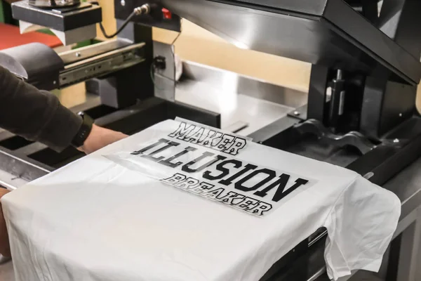 Young man printing on t-shirt