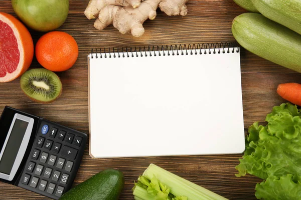 Miniräknare, anteckningsbok och olika matvaror — Stockfoto