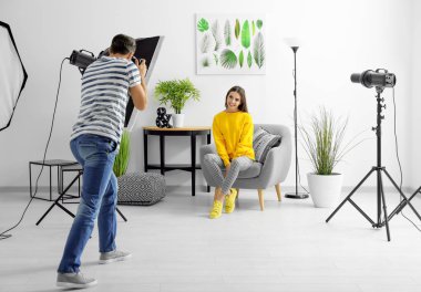Genç güzel model koltukta, stüdyo profesyonel fotoğrafçı için poz
