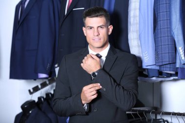 Dükkanda takım elbise giymiş yakışıklı genç