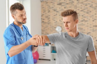 Fizyoterapist klinikte genç erkek hasta ile çalışma