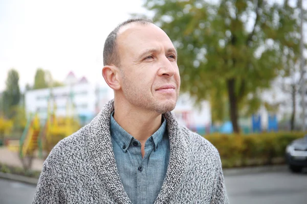 Attractive mature man in cardigan outdoors