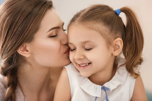 Mutter küsst kleine Tochter — Stockfoto