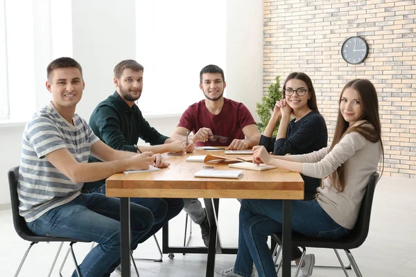 Junge Leute sitzen zusammen am Tisch — Stockfoto