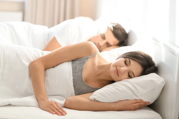 Pareja joven durmiendo en la cama — Foto de Stock