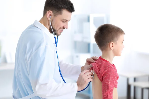 Children's doctor examining little boy in hospital — Stock Photo, Image