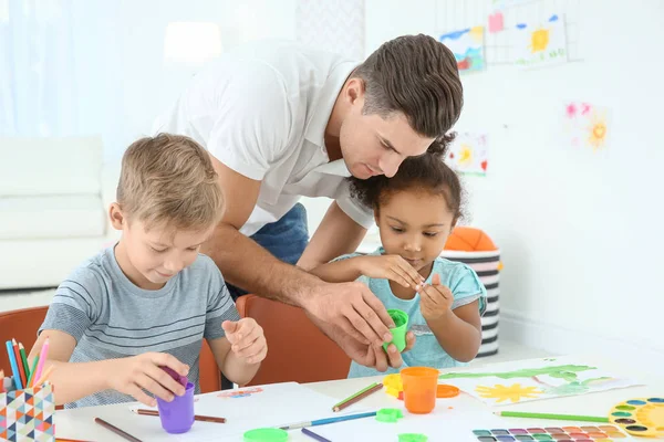Young man and little kids playing — Stock Photo, Image