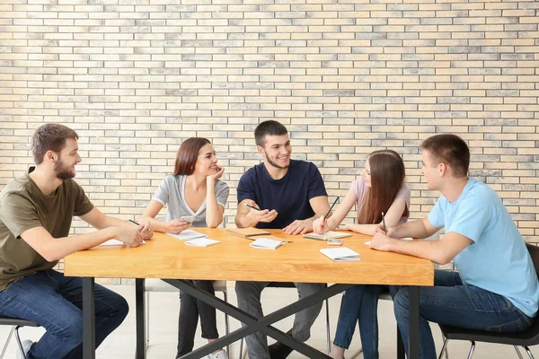 = jóvenes sentados juntos en la mesa — Foto de Stock