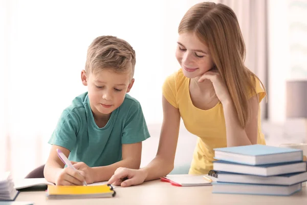 Cute little boy doing homework with elder sister — Stock Image Cute little boy doing homework with elder sister Royalty Free Stock Photos
