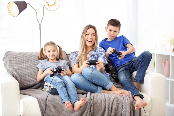 在家里和孩子们玩电子游戏的年轻女子 — 图库照片