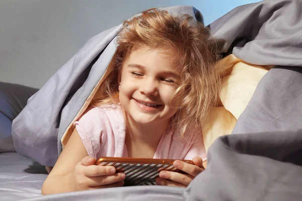 Schattig meisje spelen met telefoon — Stockfoto