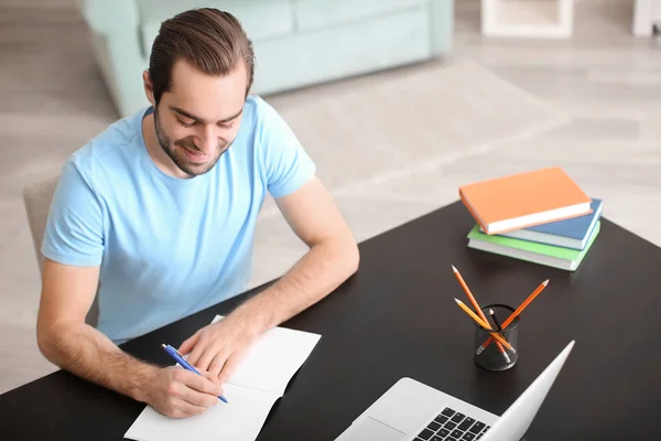 Estudiante con portátil estudiando en la mesa en interiores —  Fotos de Stock