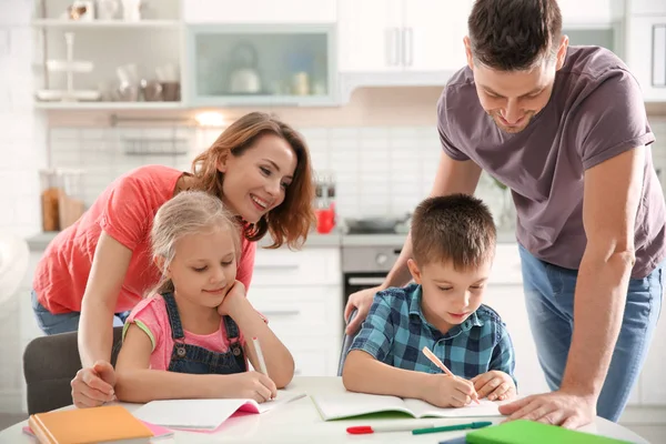Діти з батьками роблять домашнє завдання — стокове фото