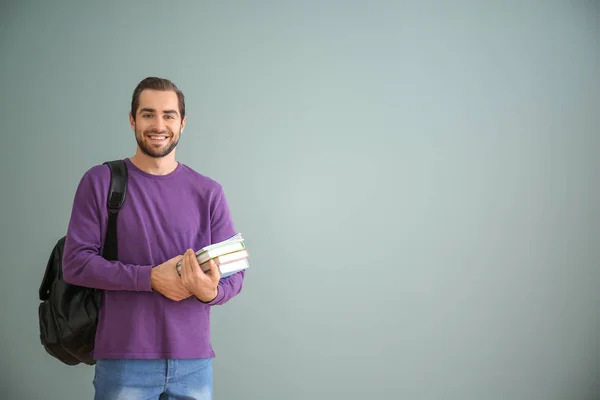 Student with notebooks on color background — Stock Photo, Image