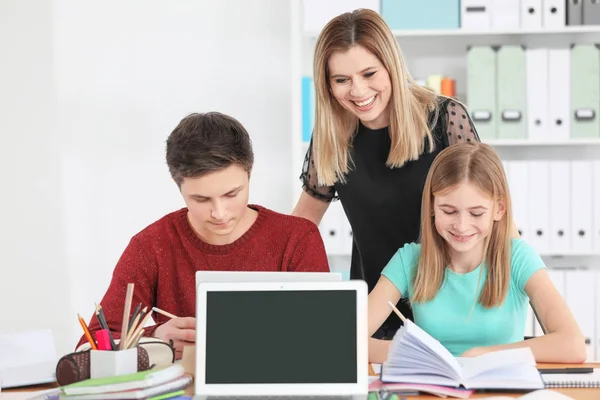 Adolescentes fazendo lição de casa com o professor — Fotografia de Stock