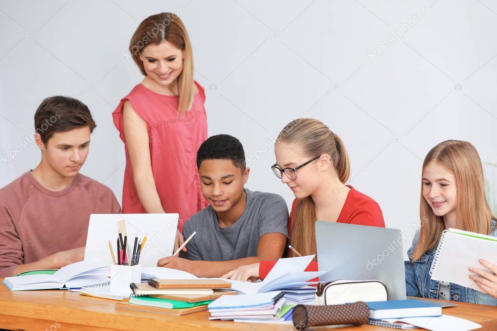 teenagers doing homework with teacher