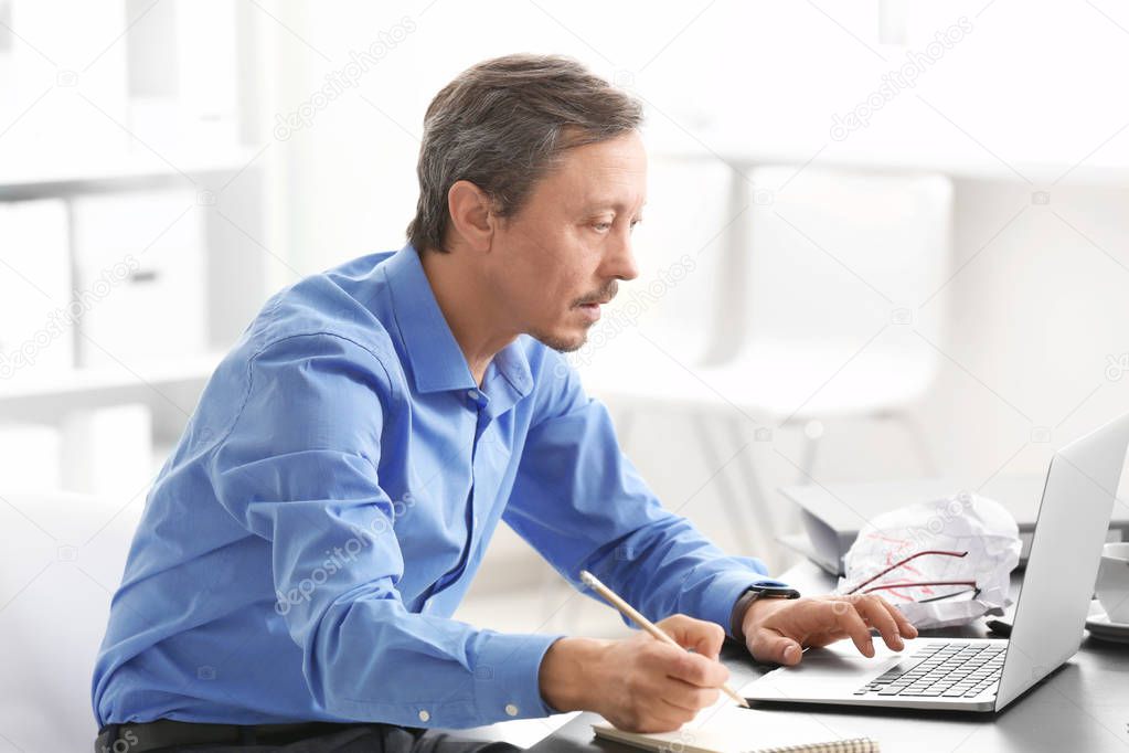 Handsome man working with laptop indoors