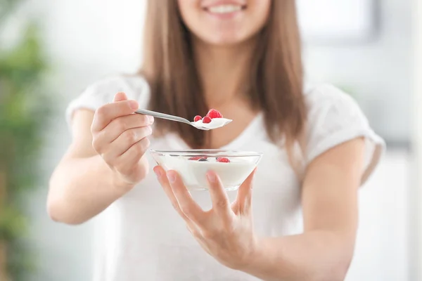 Young woman eating yogurt on blurred background — dairy, organic - Stock  Photo | #167937854