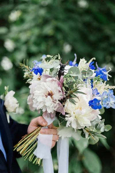 Groom holding a wedding bouquet — Stock Photo, Image