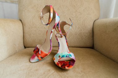 Renkli sandalet bej sandalyeye vardır