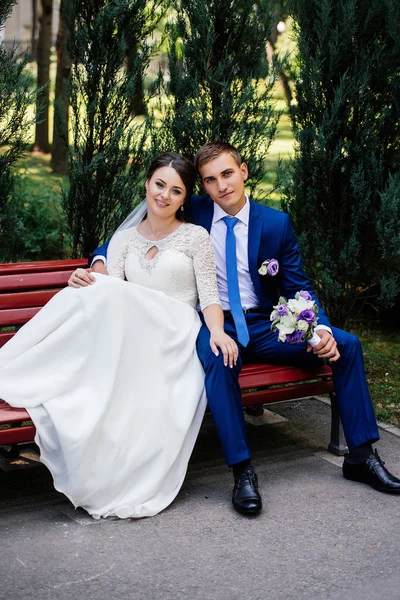 Gelin ve damat bir bankta oturup. Gelin Damat hugs