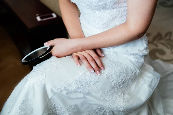 穿着白色婚纱的新娘坐着，手握紧一面镜子 — 图库照片