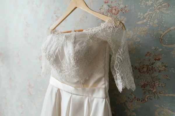 Robe de mariée en dentelle suspendue au mur — Photo