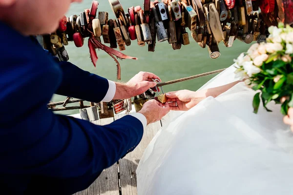 Fechadura de casamento de ouro na forma de coração nas mãos da noiva — Fotografia de Stock