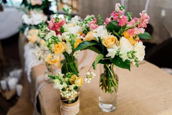 Bouquets de casamento de rosas amarelas, brancas e rosa estão em vasos — Fotografia de Stock