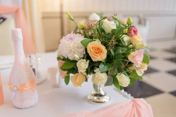 Букет из белых, кремовых и розовых цветов стоит в вазе на полу. — стоковое фото