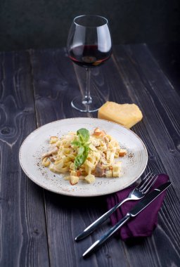 Et ve beyaz bir tabak ve bir kadeh şarap mantarlı makarna
