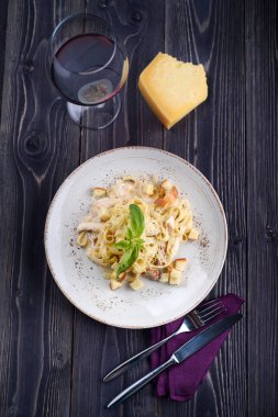 Et ve beyaz bir tabak ve bir kadeh şarap mantarlı makarna