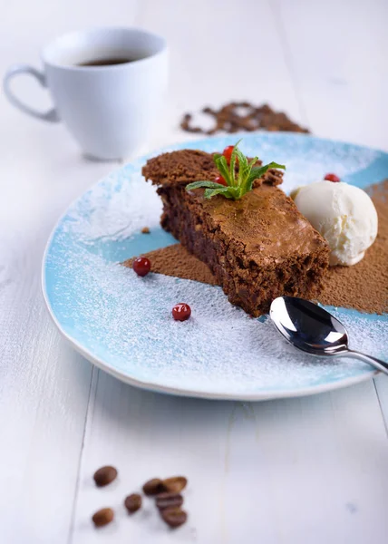 Bolinho de chocolate com sorvete em um prato azul ao lado de uma xícara de café. Bolo de chocolate com café — Fotografia de Stock