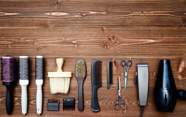 Kuaför araçlar ahşap arka plan üzerinde. Üstten görünüm makas, tarak, hairclipper, fırçaları ve saç kurutma makinesi, boş alan ahşap tablo. Berber dükkanı